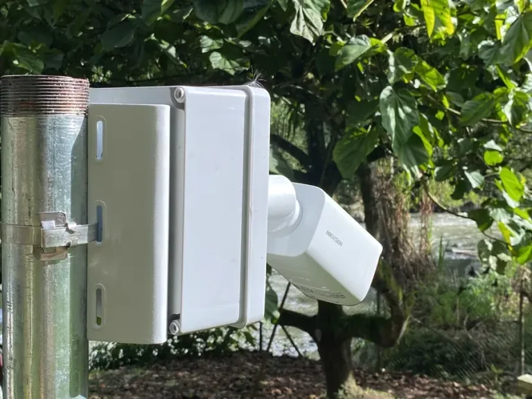 Cámara IP exterior instalada sobre poste junto a una bocatoma
