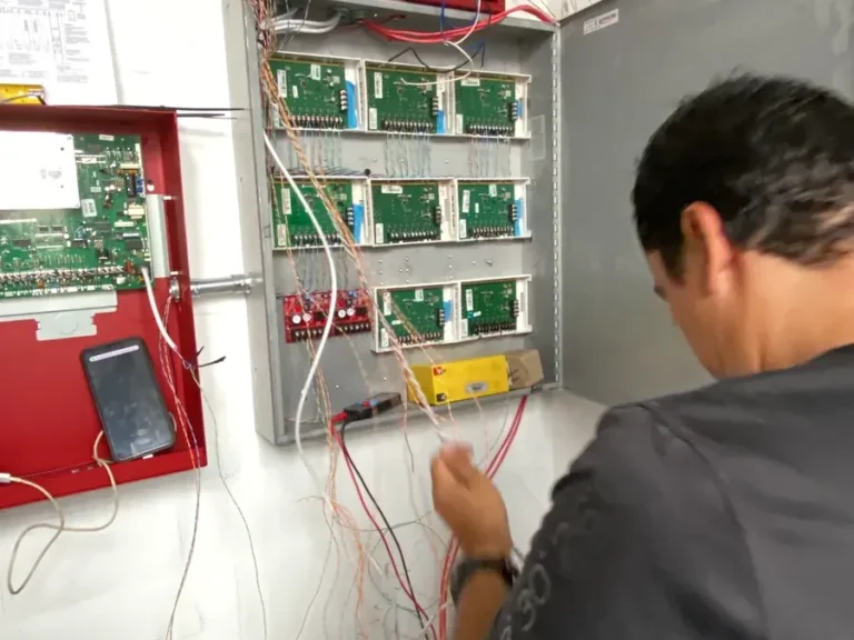 Técnico conectando módulos en el gabinete del sistema de incendios