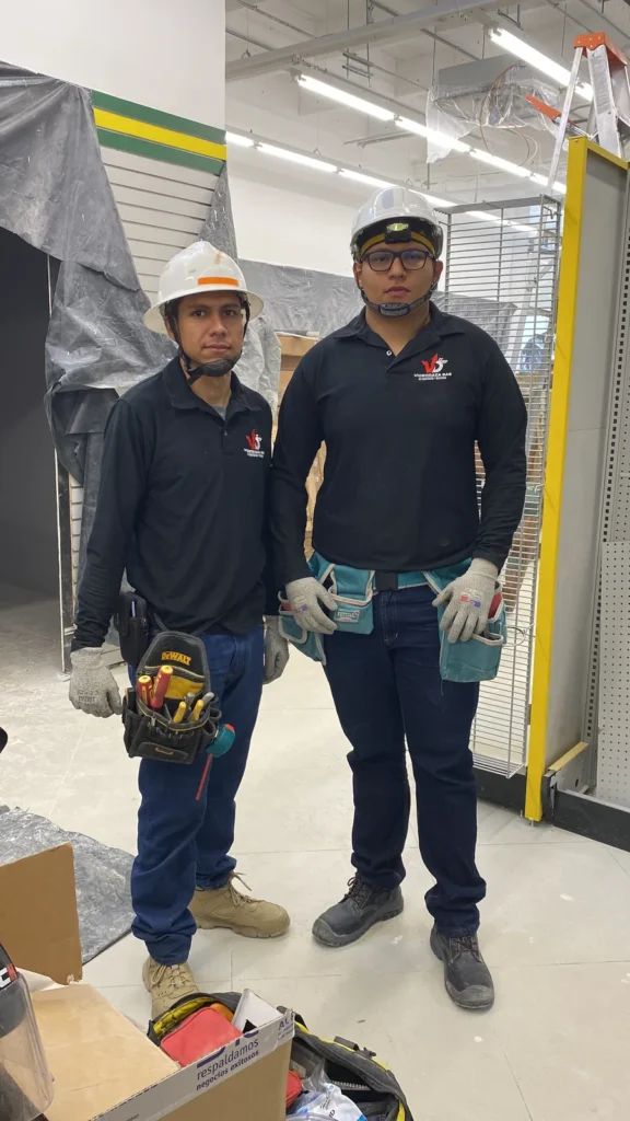 Dos técnicos de Videodaza SAS con casco y herramienta en una obra comercial